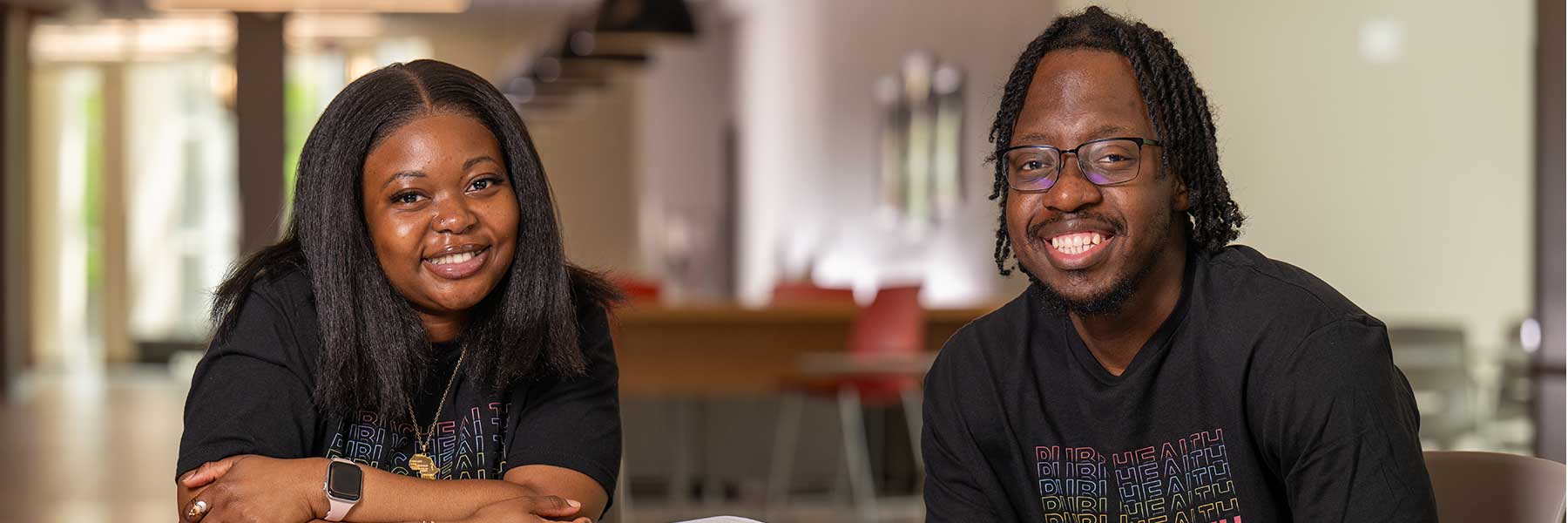 two public health students together at table with open books