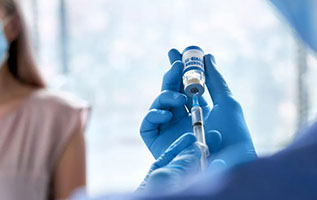 health worker in blue gloves prepares covid-19 vaccination